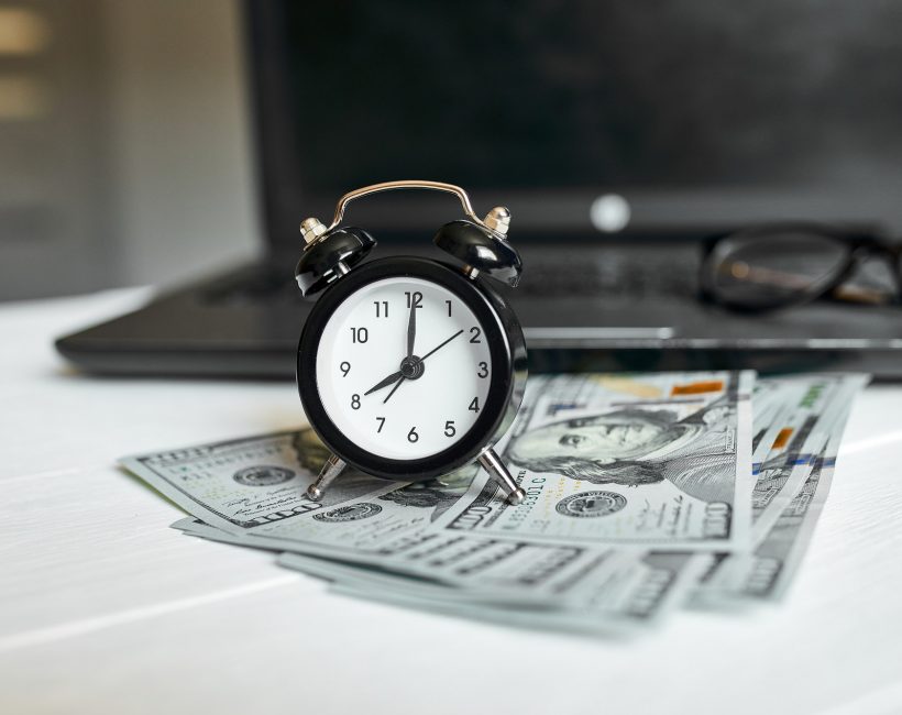 Modern workplace of laptop, clock, money, dollars banknote